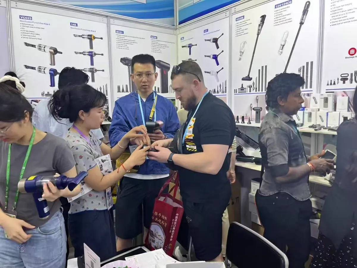 Buyer testing a handheld vacuum cleaner at the DRC booth